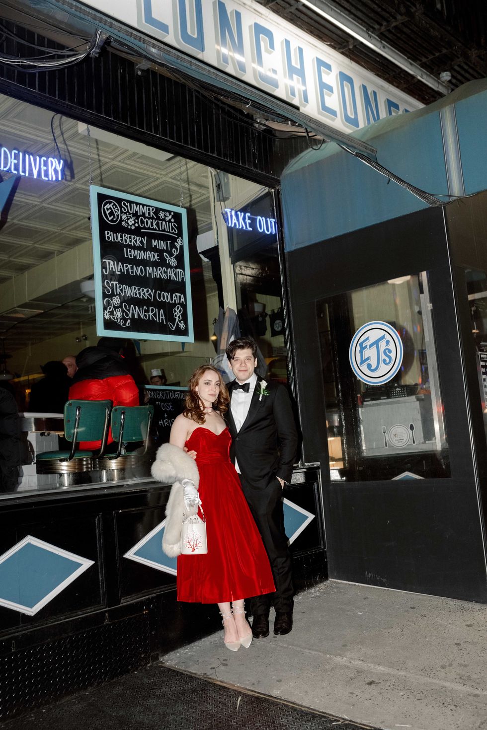a man and woman posing for a picture in front of a store