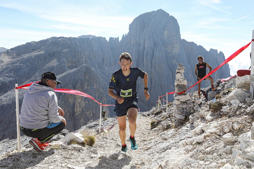 trail race in a mountainous terrain with runners and spectators