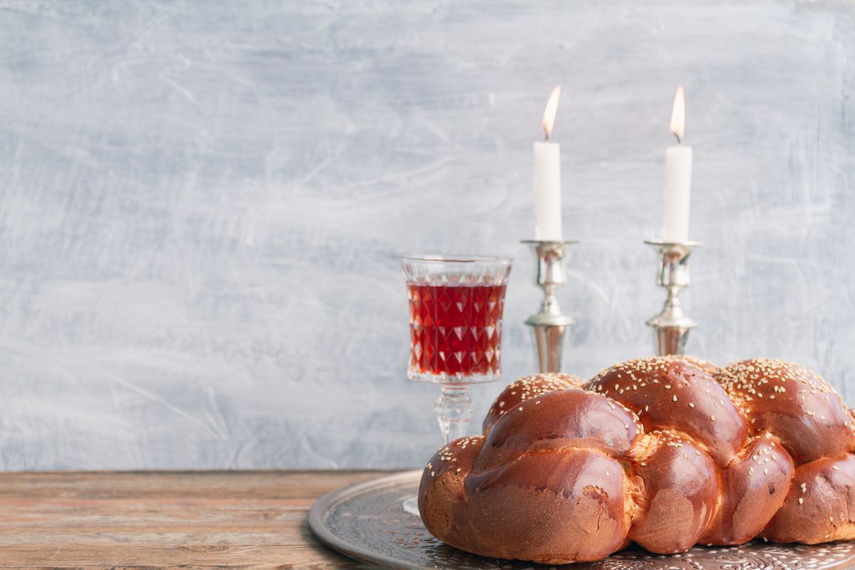 rosh hashanah prayers loaf of challah with two candlesticks and a glass of wine