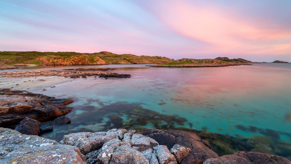 ross of mull sandy beach at sunset with clouds and crystal water