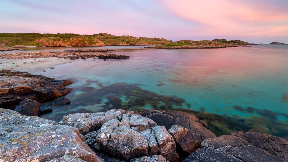 ross of mull sandy beach at sunset with clouds and crystal water