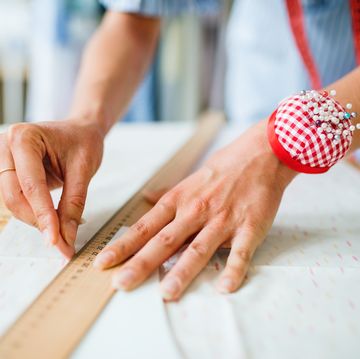 woman's hands measuring fabric with a ruler