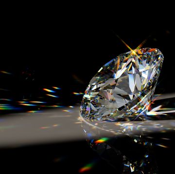round cut diamond on black background with beautiful colorful caustics rays
