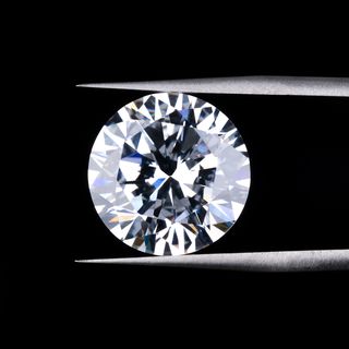 round diamond clamped by tweezers