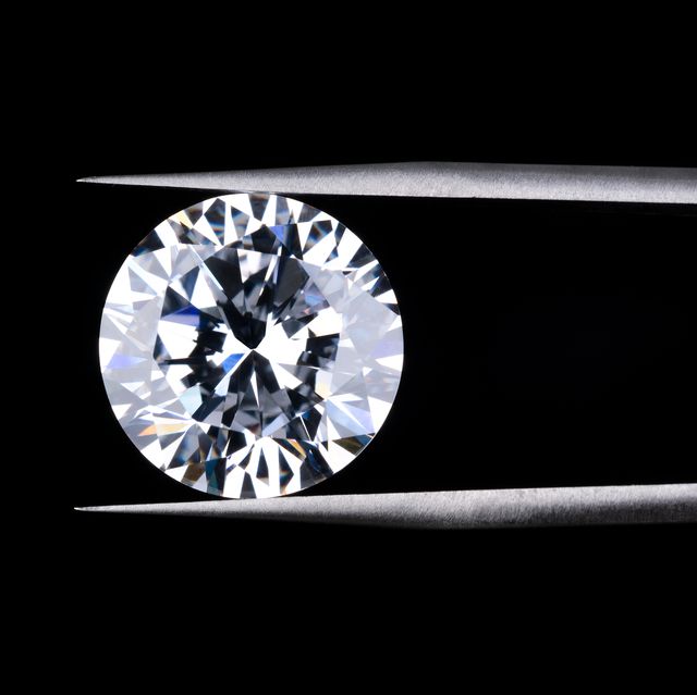 round diamond clamped by tweezers