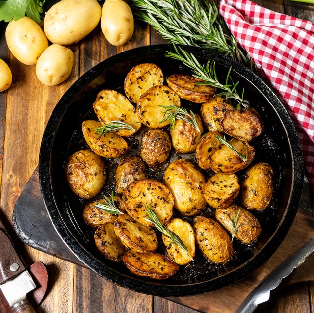 round roasting pan with delicious roasted potatoes with fresh and natural herbs concept of home cooking, healthy food,