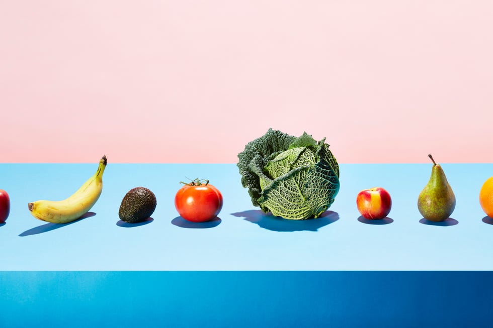 a row of different fruits and vegetables on a table top