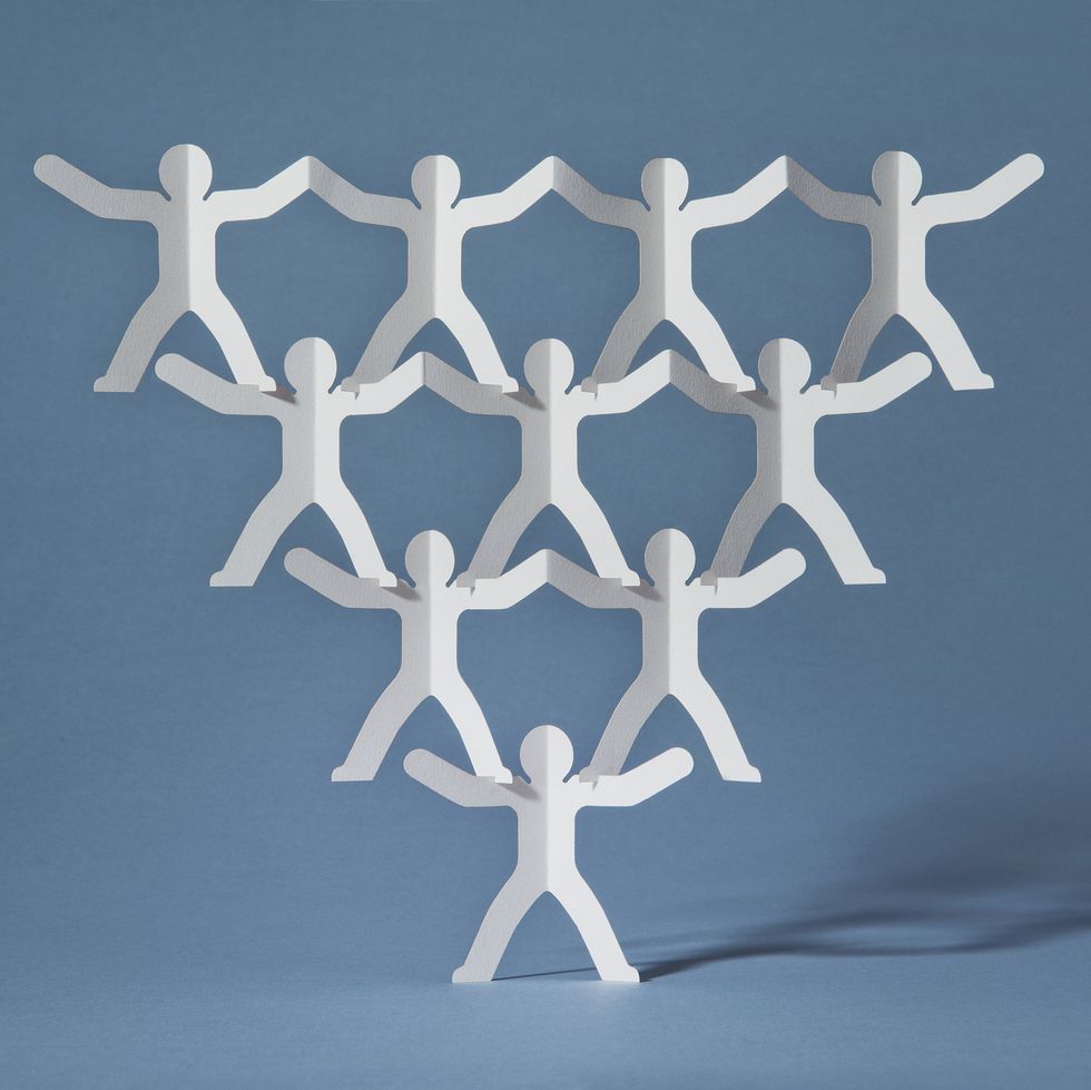 Rows of paper cut-out men balancing on one