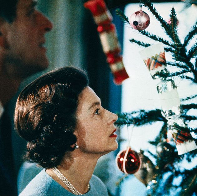 original caption christmas at windsor castle is shown here with queen elizabeth ii and prince philip shown putting finishing touches to christmas tree, in a photo made recently during the filming of the joint itv bbc film documentary, the royal family