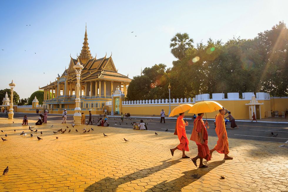 Boeddhistische monniken lopen langs het Koninklijk Paleis in Phnom Penh Cambodja