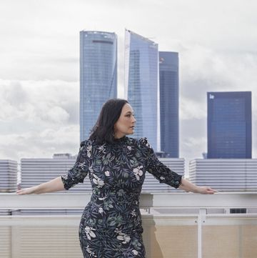 a woman standing on a balcony overlooking a city