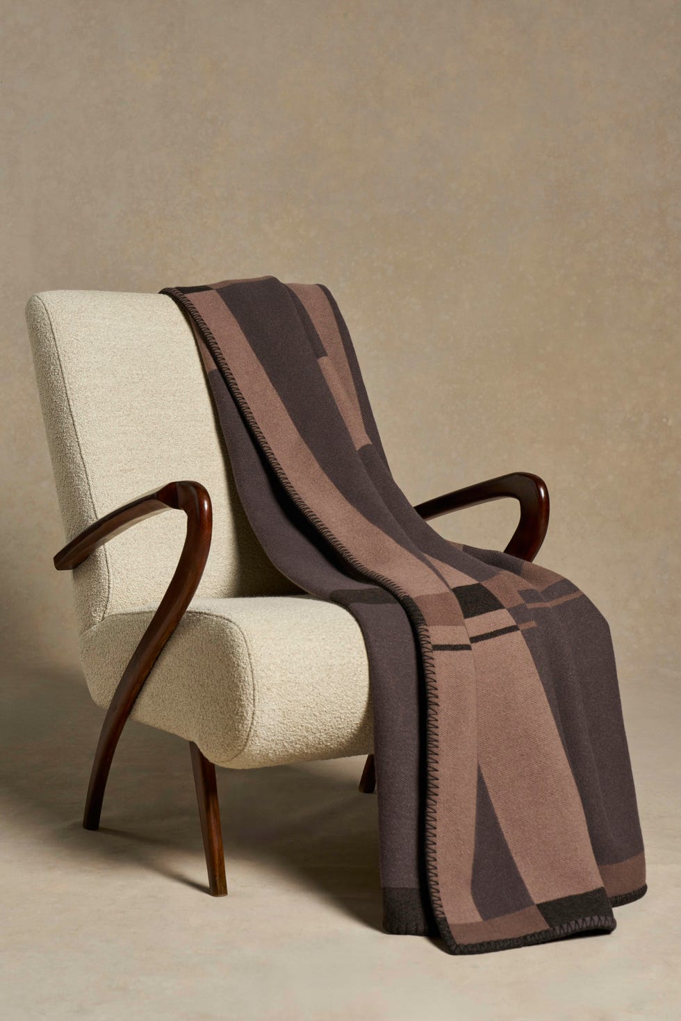 blanket is shades of brown on cream armchair