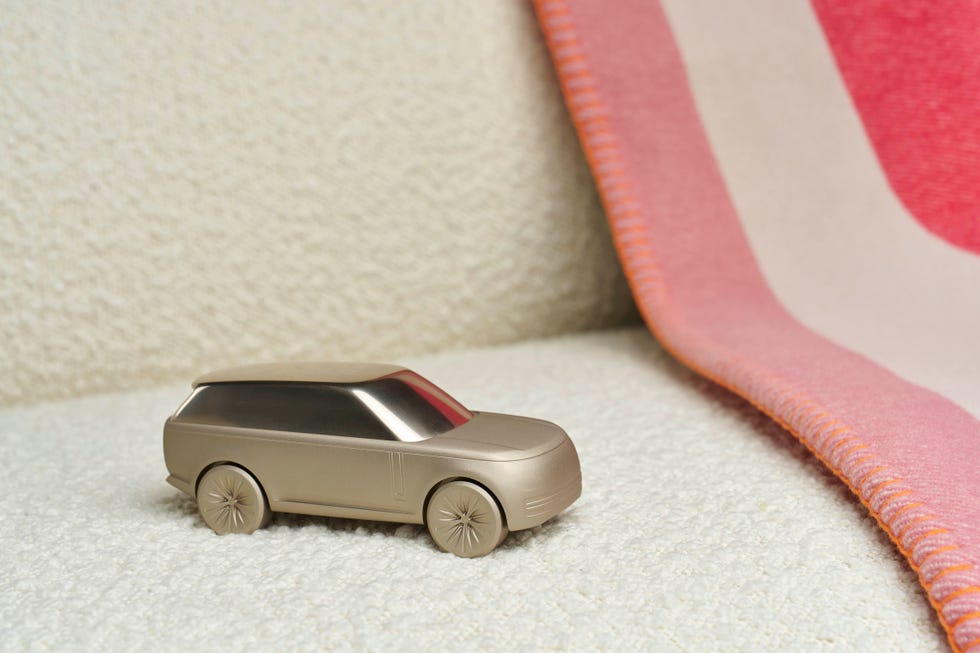 small sculpture of rabge rover car sat on a couch