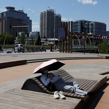 https://i.natgeofe.com/n/91f7f47e-81e3-42f5-893c-34e9a7721b1d/RTS7VIRC.jpg In Peking gebruikt een zwangere vrouw een paraplu om zich tegen de felle zon te beschermen