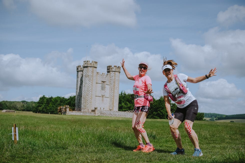 two animated women on a trail run near a castle