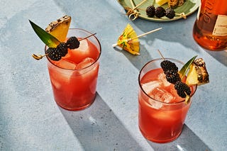 rum runner cocktail garnished with pineapple and blackberries