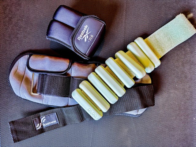 assorted brands of ankle weights on a textured surface