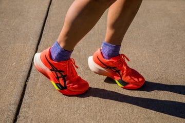 a person wearing a pair of asics metaspeed edge paris carbon plated running shoes