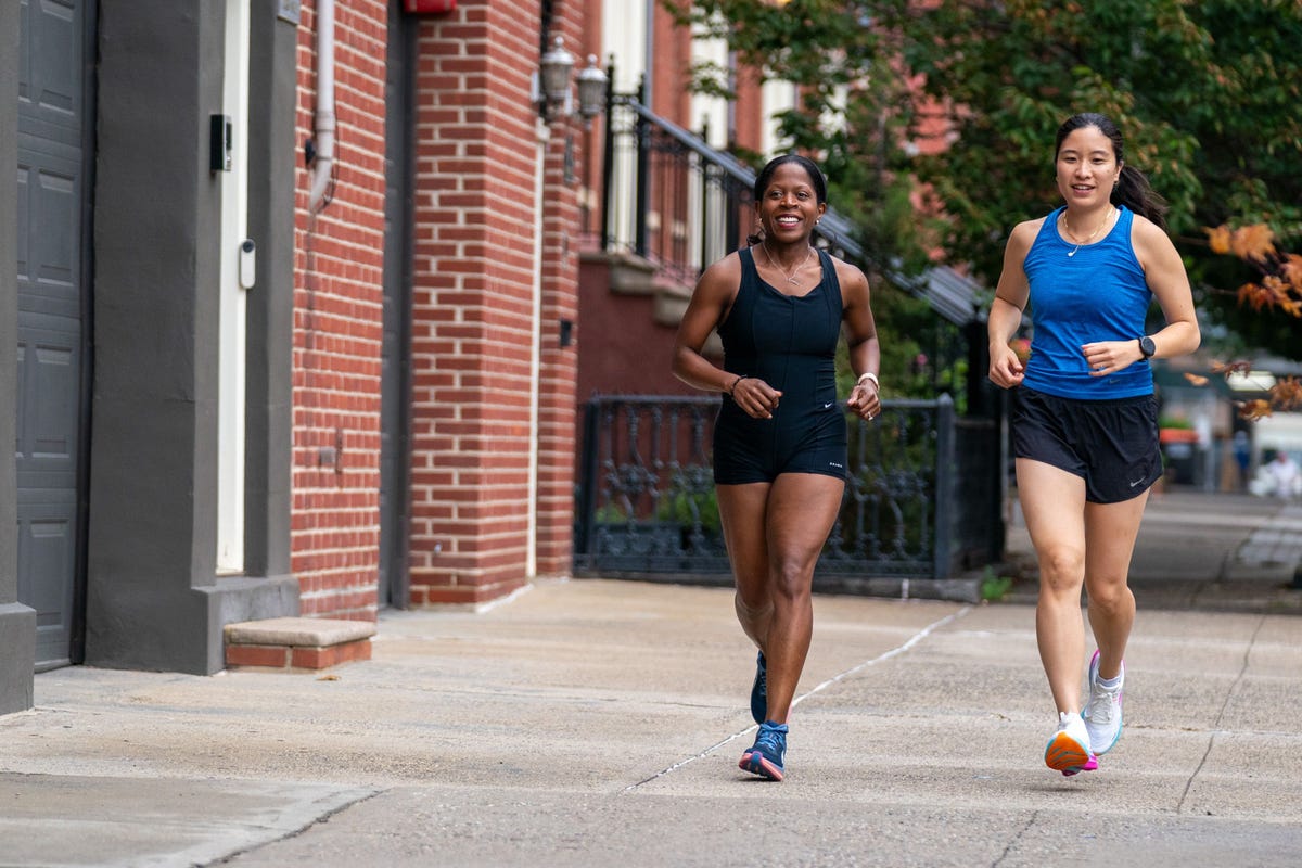 two women jogging on a city sidewalk