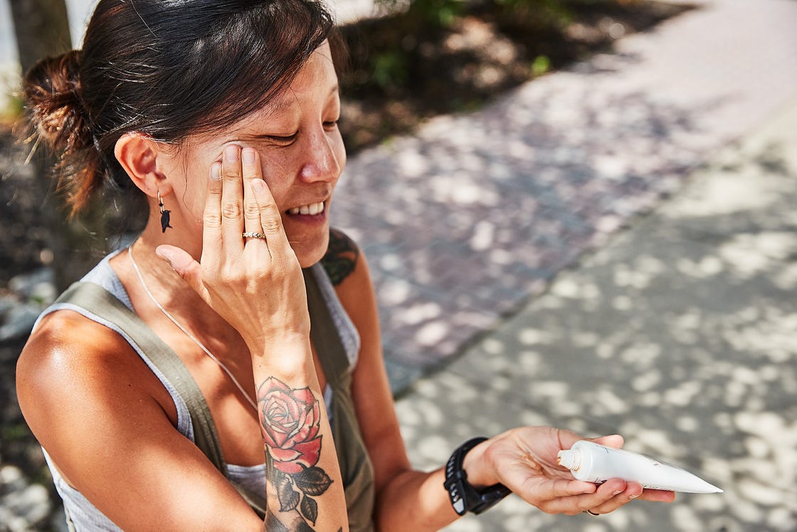 a person applying sunscreen to their face