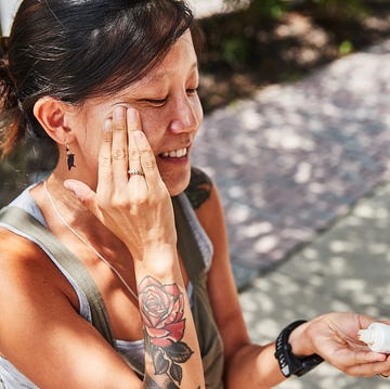 a person applying sunscreen to their face a person applying sunscreen to their face