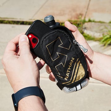 Best Water Bottles for Runners, Hikers, and Travelers a person putting their phone into a handheld water bottle pouch