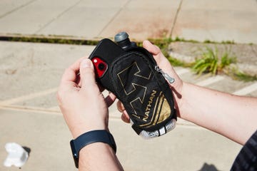 a person putting their phone into a handheld water bottle pouch