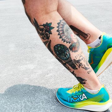 person with tattooed calves jogging in hoka running shoes