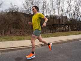 a person jogging on a sidewalk in casual athletic wear