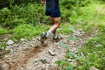 a person running in hoka mafate speed 4 running shoes on a trail