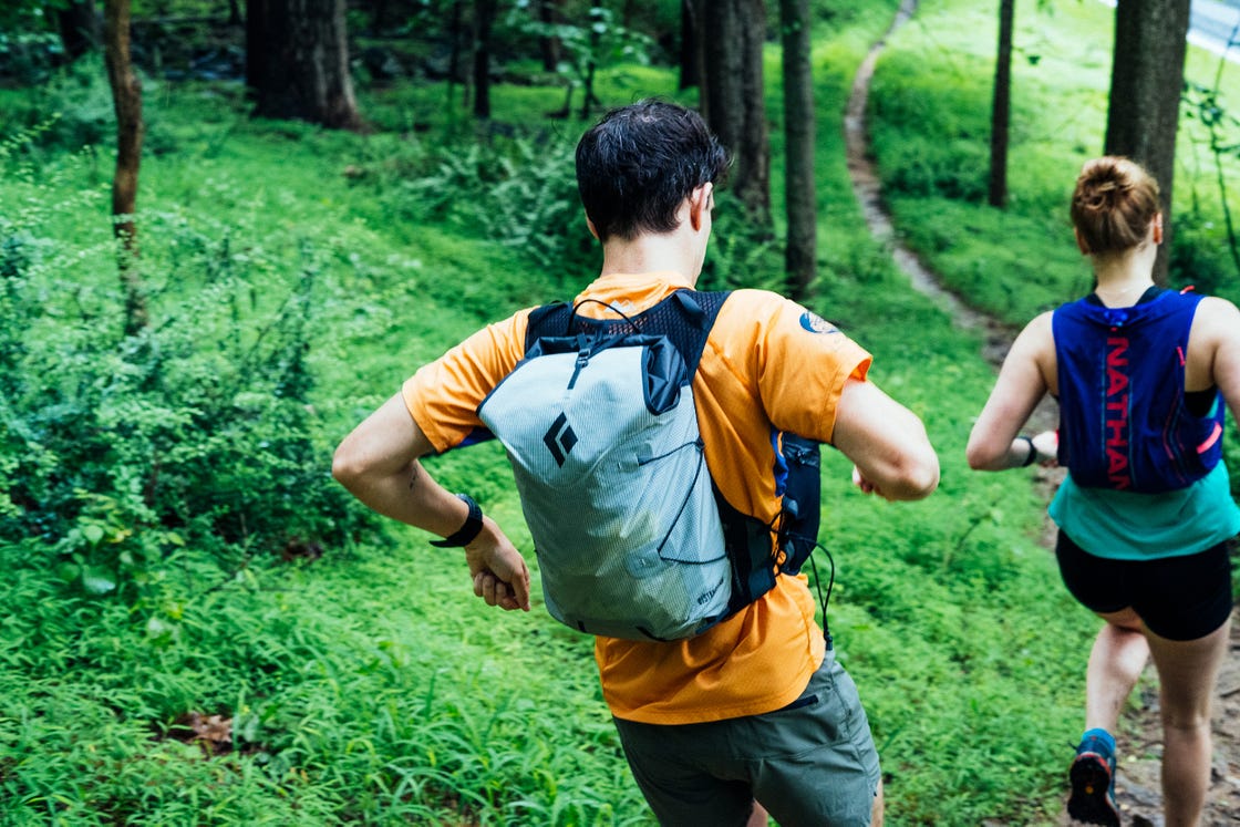 a couple of people running in the woods