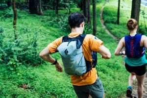 a couple of people running in the woods