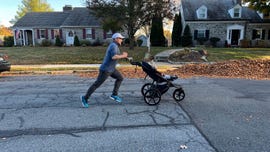 a man jogging pushing a stroller with a child in it