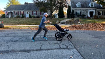 a man jogging pushing a stroller with a child in it