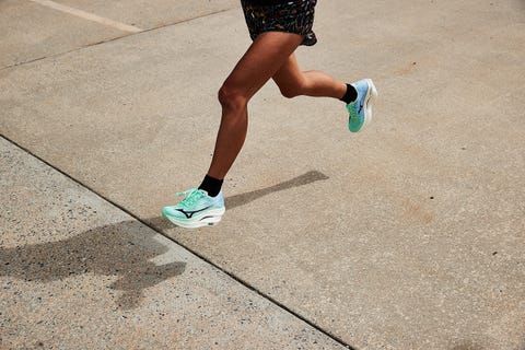 a woman running in mizuno wave rebellion pro 3 running shoes