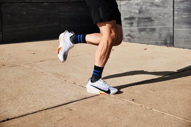 person running in Rise Nike shoes on sidewalk