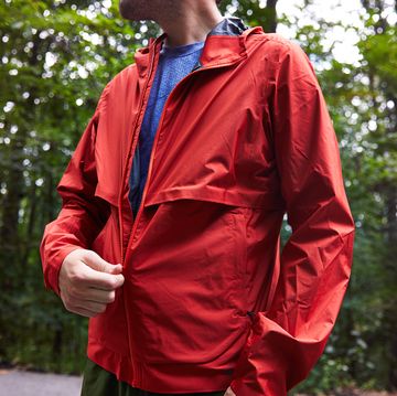 pulling up zipper on red boot running jacket