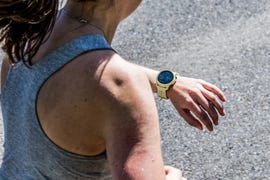a woman running with her coros pace running watch