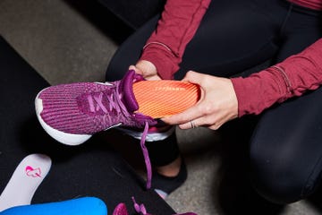 a person putting a shoe insert into their shoe