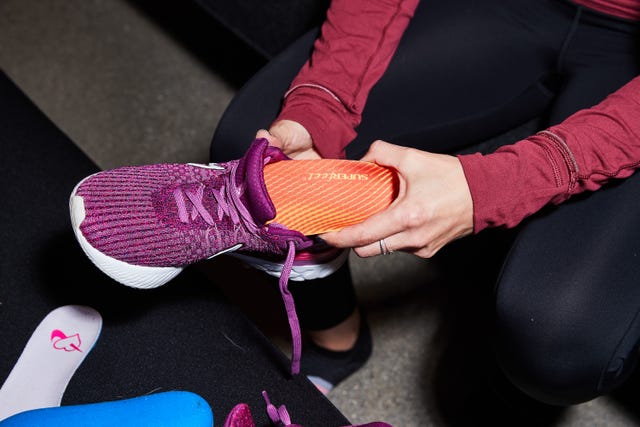 a person putting a shoe insert into their shoe