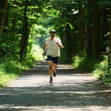 A person jogging on a dirt path surrounded by trees a person jogging on a dirt path surrounded by trees