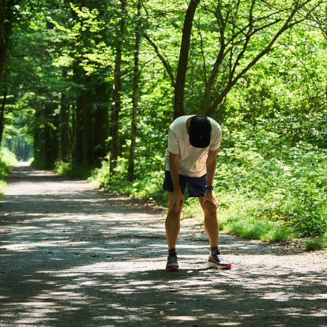 a runner with hands on his knees after a hard effort