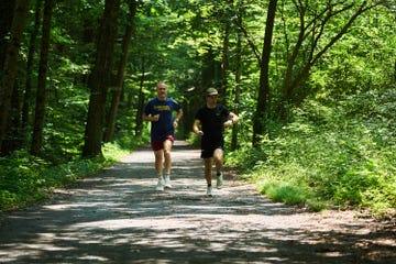 two men running Mafate on a path in the woods