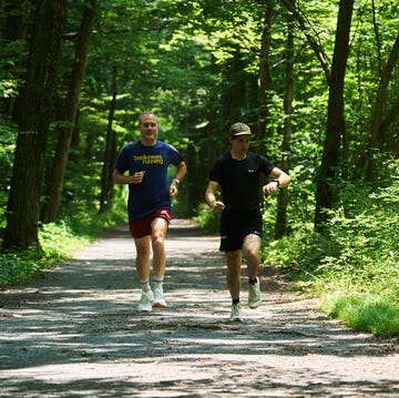 RWD two men running on a path in the woods