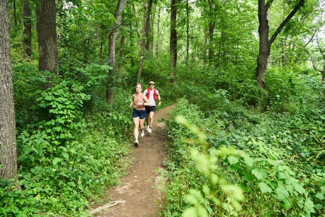 two people running in the woods