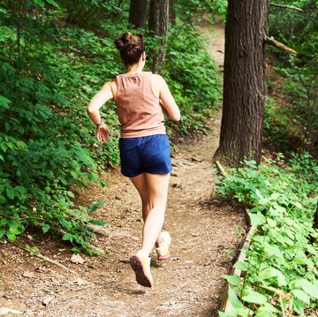 woman denim running in woods for ql stretches