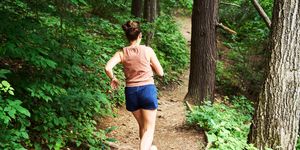 woman running in woods for ql stretches