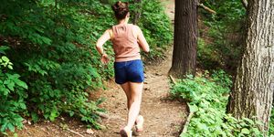 woman running in woods for ql stretches