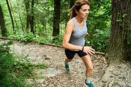 jen acker running up a trail in the summer