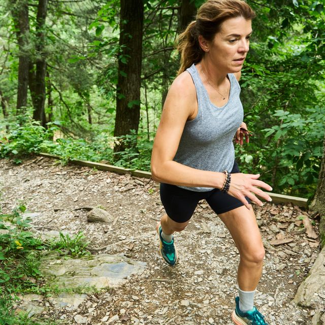 jen acker running up a trail in the summer